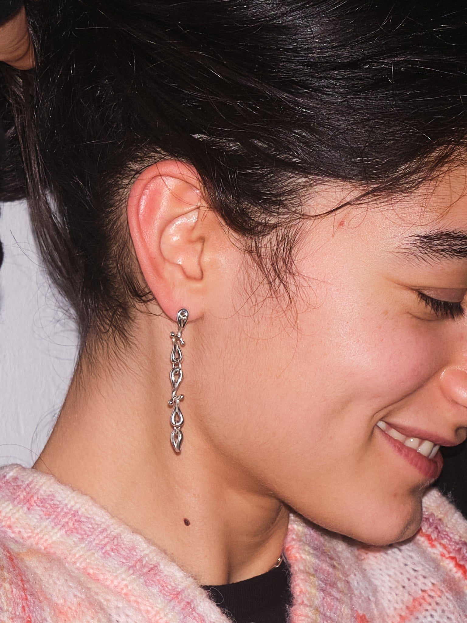 Photo of a Woman with brown hair, wearing the AUDO Sterling Silver Dangle Earring on hear ear.